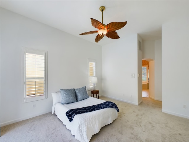 bedroom featuring light carpet and multiple windows