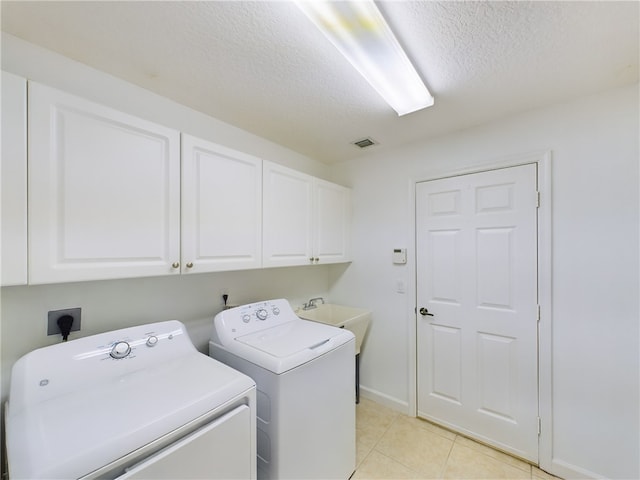 clothes washing area featuring cabinet space, light tile patterned floors, visible vents, independent washer and dryer, and a textured ceiling