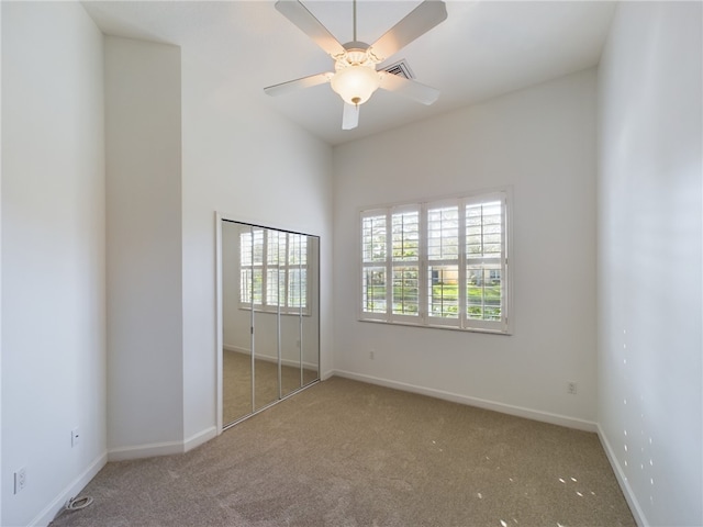 unfurnished bedroom featuring a ceiling fan, carpet, visible vents, and baseboards