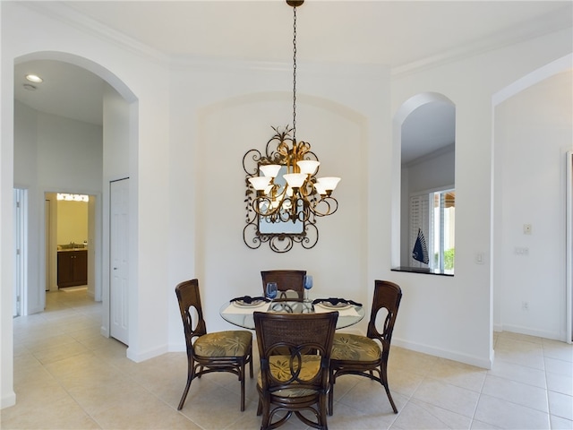 dining room featuring a chandelier, ornamental molding, light tile patterned flooring, and baseboards