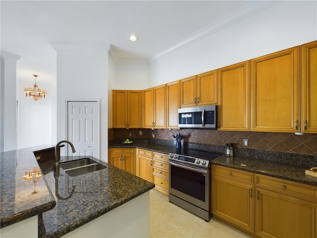 kitchen with tasteful backsplash, dark stone counters, appliances with stainless steel finishes, ornamental molding, and a sink