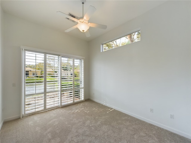 spare room with carpet floors, baseboards, and a ceiling fan