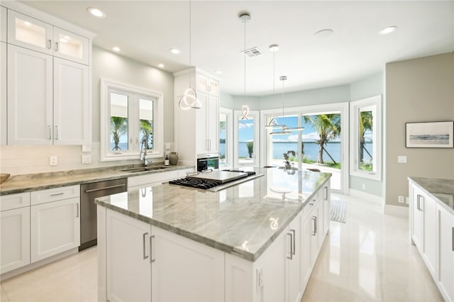526 Point Ln, Vero Beach, FL 32963 - kitchen with cooktop, a kitchen island, glass insert cabinets, a sink, and stainless steel dishwasher