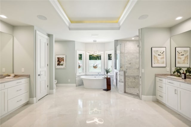 526 Point Ln, Vero Beach, FL 32963 - full bathroom with a tray ceiling, baseboards, a stall shower, a freestanding bath, and two vanities