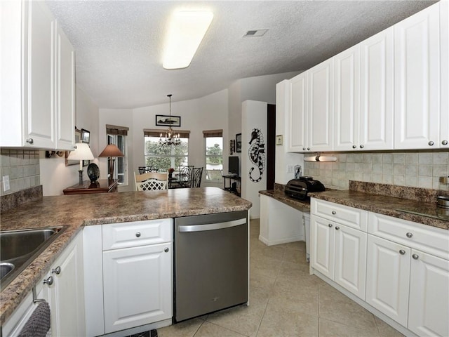 kitchen with stainless steel dishwasher, lofted ceiling, and white cabinets