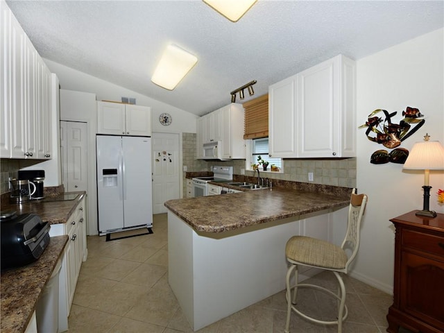 kitchen with white cabinetry, white appliances, kitchen peninsula, and sink