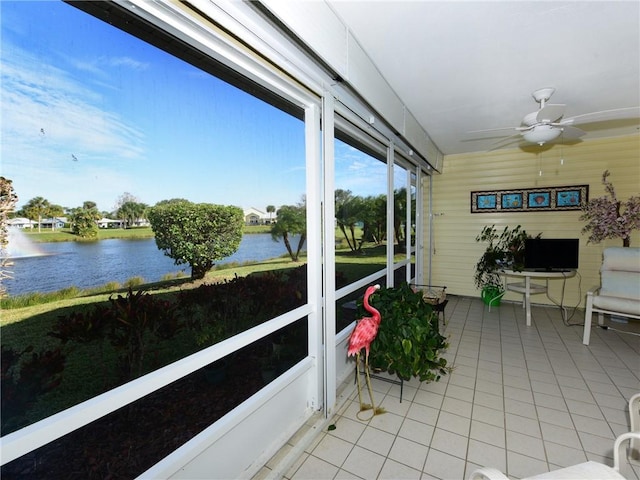 sunroom / solarium featuring a water view and ceiling fan