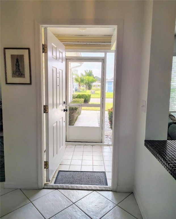 doorway to outside with light tile patterned flooring