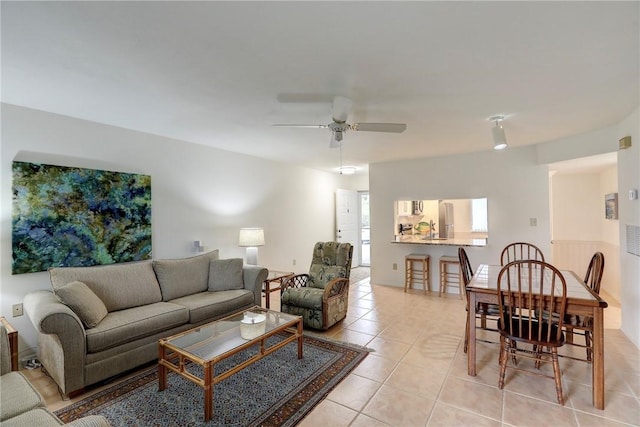 tiled living room with ceiling fan and sink