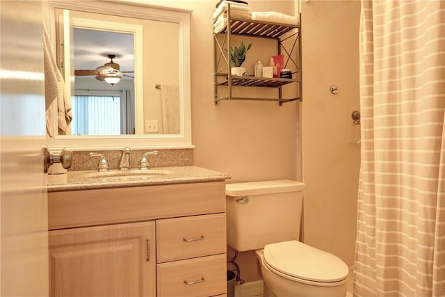 bathroom featuring toilet, vanity, and ceiling fan