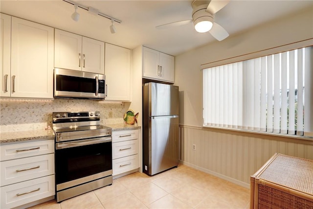 kitchen with light stone countertops, white cabinetry, ceiling fan, and appliances with stainless steel finishes