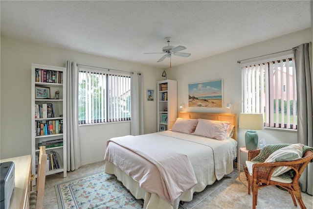 bedroom with ceiling fan and a textured ceiling