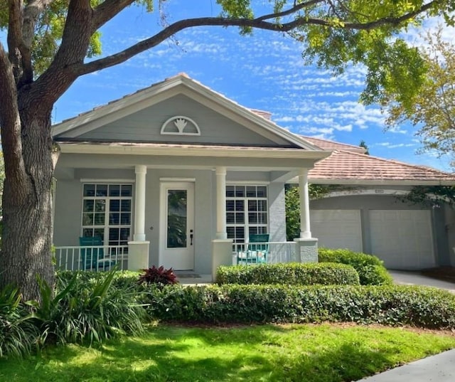 8850 E Orchid Island Cir, Vero Beach, FL 32963 - view of front facade with a garage, a porch, stucco siding, and driveway