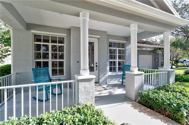 entrance to property with covered porch and a garage