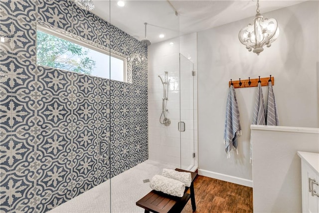 8850 E Orchid Island Cir, Vero Beach, FL 32963 - bathroom with tiled shower, healthy amount of natural light, wood finished floors, a chandelier, and recessed lighting