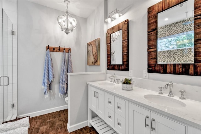 bathroom with hardwood / wood-style floors, an enclosed shower, vanity, an inviting chandelier, and toilet