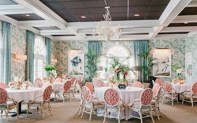 carpeted dining space featuring coffered ceiling, beamed ceiling, and a notable chandelier