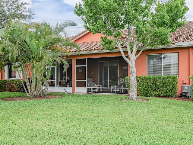 6480 Oxford Cir Unit 103C, Vero Beach, FL 32966 - back of house with a tiled roof, a yard, a sunroom, and stucco siding