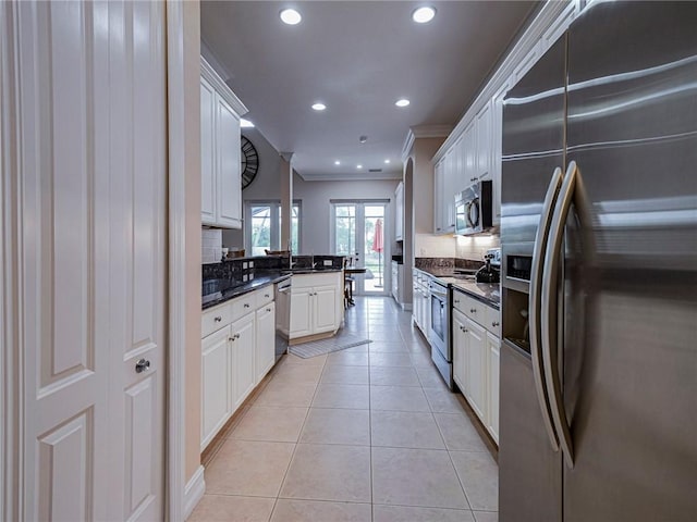 4570 Bridgepointe Way Unit 148, Vero Beach, FL 32967 - kitchen with appliances with stainless steel finishes, dark countertops, crown molding, backsplash, and recessed lighting