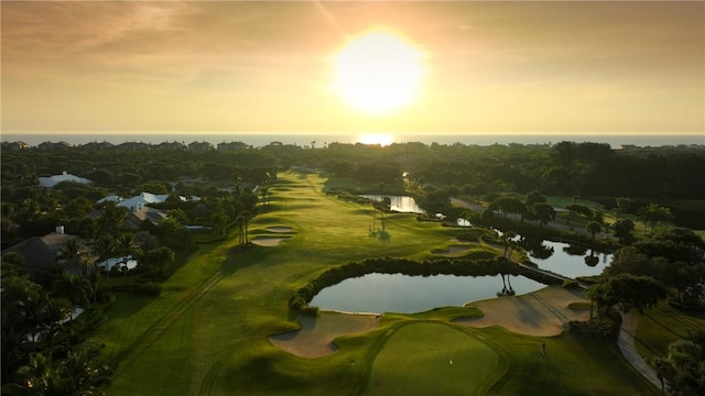 aerial view at dusk featuring a water view