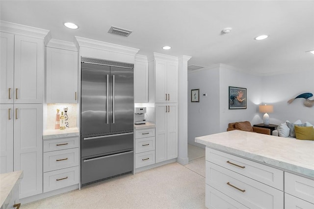 976 25th St, Vero Beach, FL 32960 - kitchen with stainless steel built in fridge, white cabinetry, recessed lighting, open floor plan, and light stone countertops