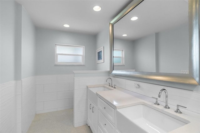 976 25th St, Vero Beach, FL 32960 - full bathroom featuring tile walls, double vanity, recessed lighting, and wainscoting