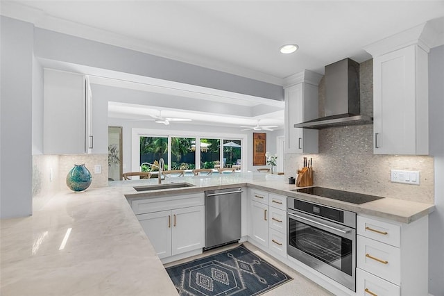 976 25th St, Vero Beach, FL 32960 - kitchen with appliances with stainless steel finishes, wall chimney exhaust hood, a ceiling fan, white cabinetry, and backsplash