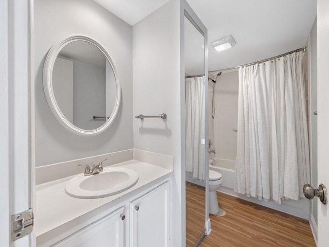 bathroom featuring shower / tub combo, vanity, toilet, and wood finished floors