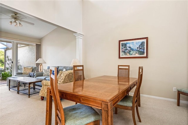 dining room with ceiling fan, light colored carpet, and decorative columns