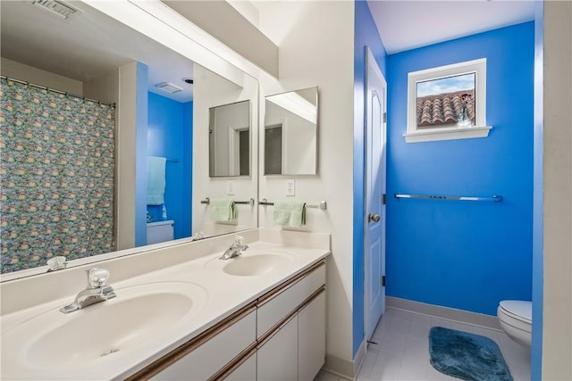 bathroom featuring vanity, tile patterned floors, and toilet