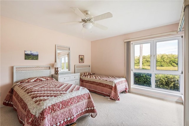 carpeted bedroom featuring ceiling fan and multiple windows