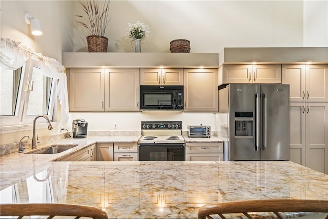 kitchen featuring a breakfast bar, sink, light stone counters, range with electric stovetop, and high quality fridge