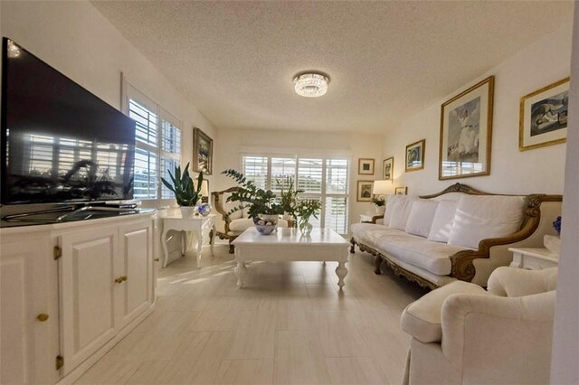 living room featuring an inviting chandelier and a textured ceiling