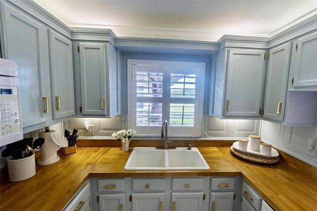 kitchen featuring wood counters, ornamental molding, backsplash, and white appliances