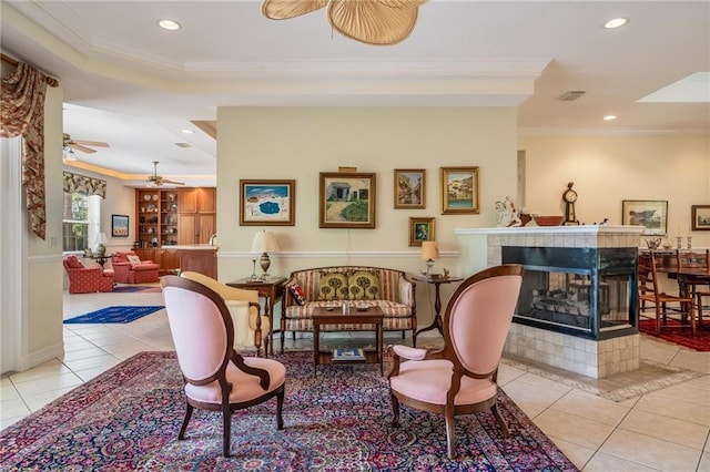 living area featuring light tile patterned floors, recessed lighting, a tile fireplace, and crown molding