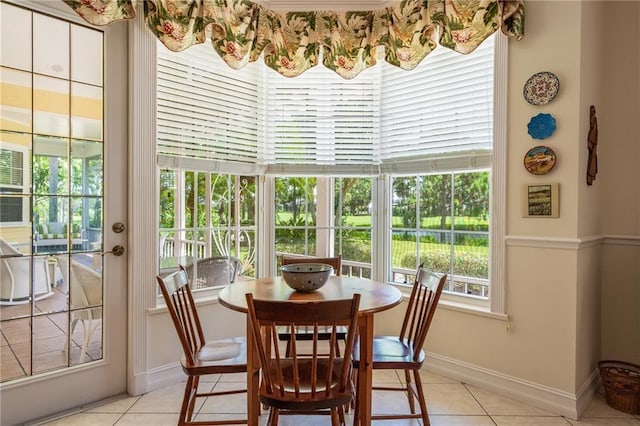 dining space featuring light tile patterned floors and baseboards