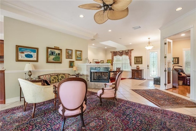 living room featuring a tile fireplace, crown molding, recessed lighting, and light tile patterned floors