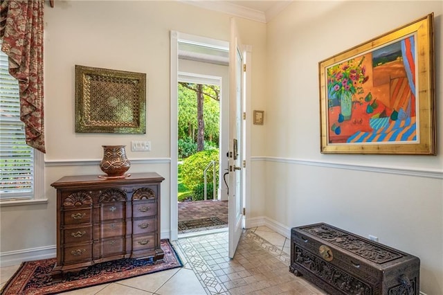 entryway featuring light tile patterned floors, baseboards, and crown molding