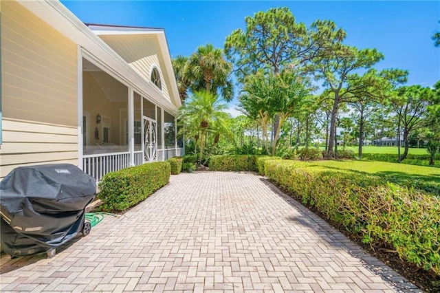 view of patio / terrace featuring a sunroom and grilling area