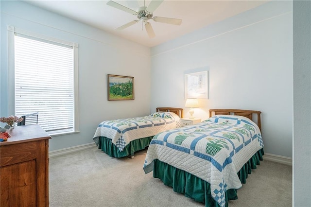 bedroom featuring light carpet, ceiling fan, and baseboards