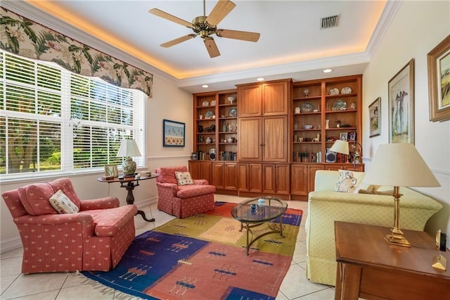 sitting room featuring a tray ceiling, visible vents, crown molding, and light tile patterned flooring