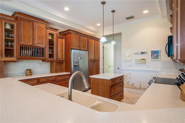 kitchen featuring stainless steel fridge, visible vents, brown cabinetry, glass insert cabinets, and light countertops