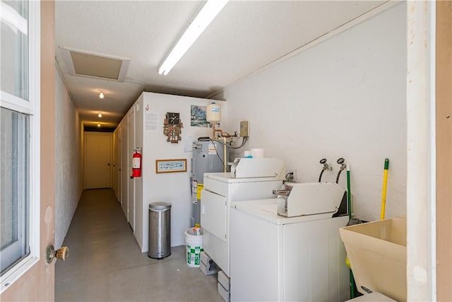 laundry area with laundry area, attic access, a sink, electric water heater, and washer and clothes dryer