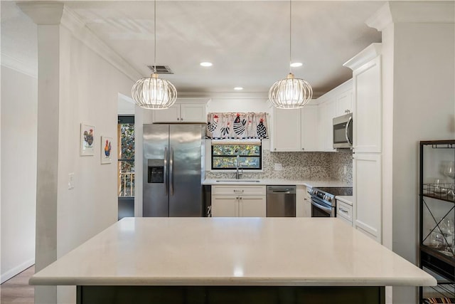 kitchen featuring visible vents, ornamental molding, a sink, tasteful backsplash, and appliances with stainless steel finishes