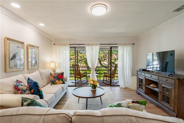 living room with visible vents, crown molding, recessed lighting, wood finished floors, and a textured ceiling