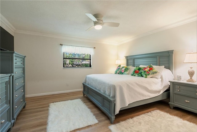 bedroom featuring ceiling fan, wood finished floors, baseboards, and ornamental molding