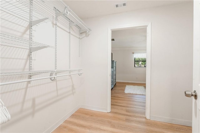 walk in closet with wood finished floors and visible vents