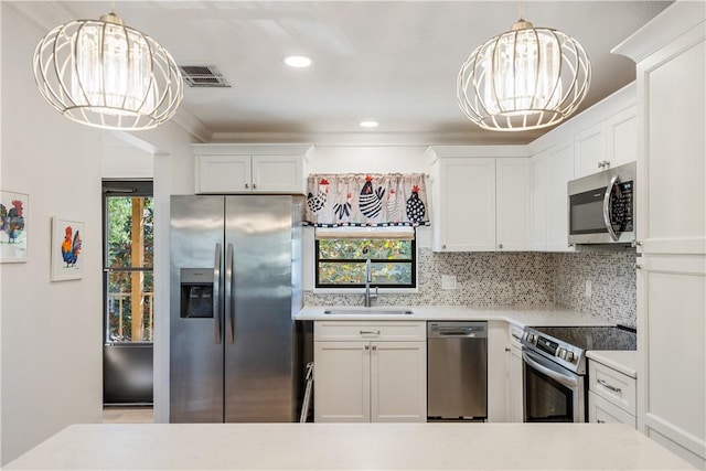 kitchen with stainless steel appliances, light countertops, an inviting chandelier, and a sink