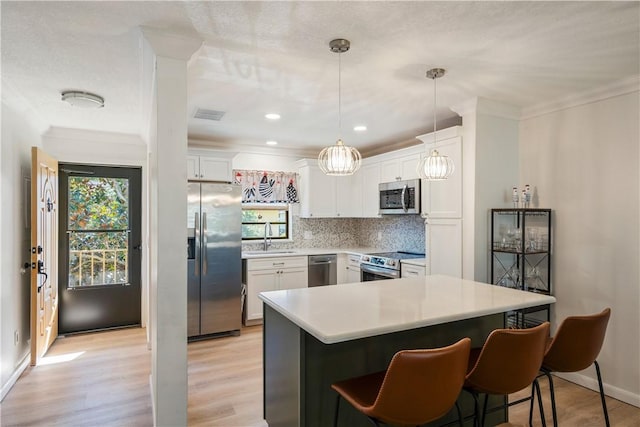 kitchen with decorative backsplash, white cabinetry, stainless steel appliances, and a sink