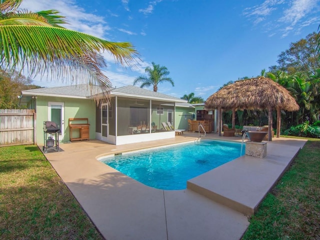 view of pool featuring a sunroom, a gazebo, a lawn, and a patio